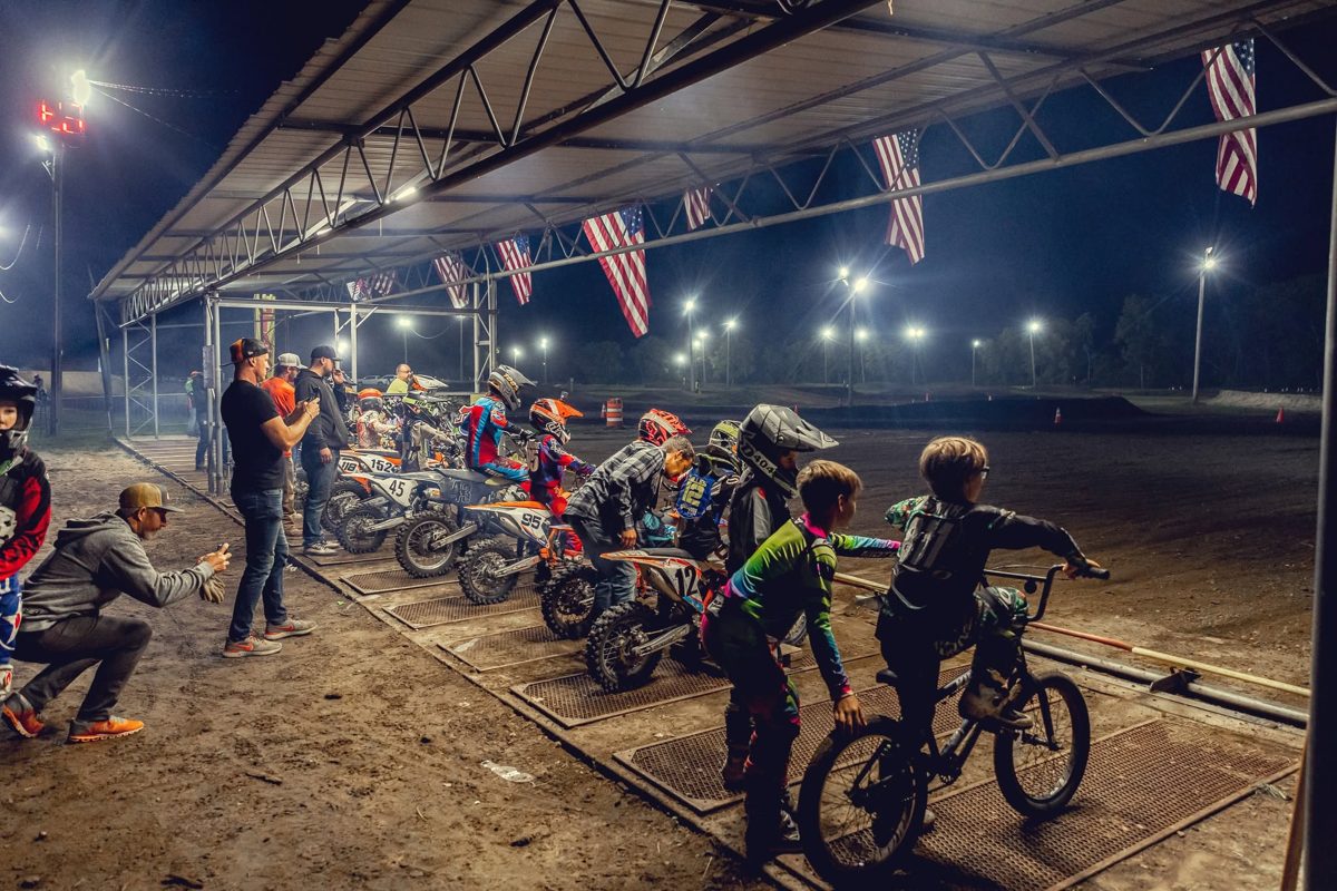 Young riders at the Joliet MX starting gate under the lights